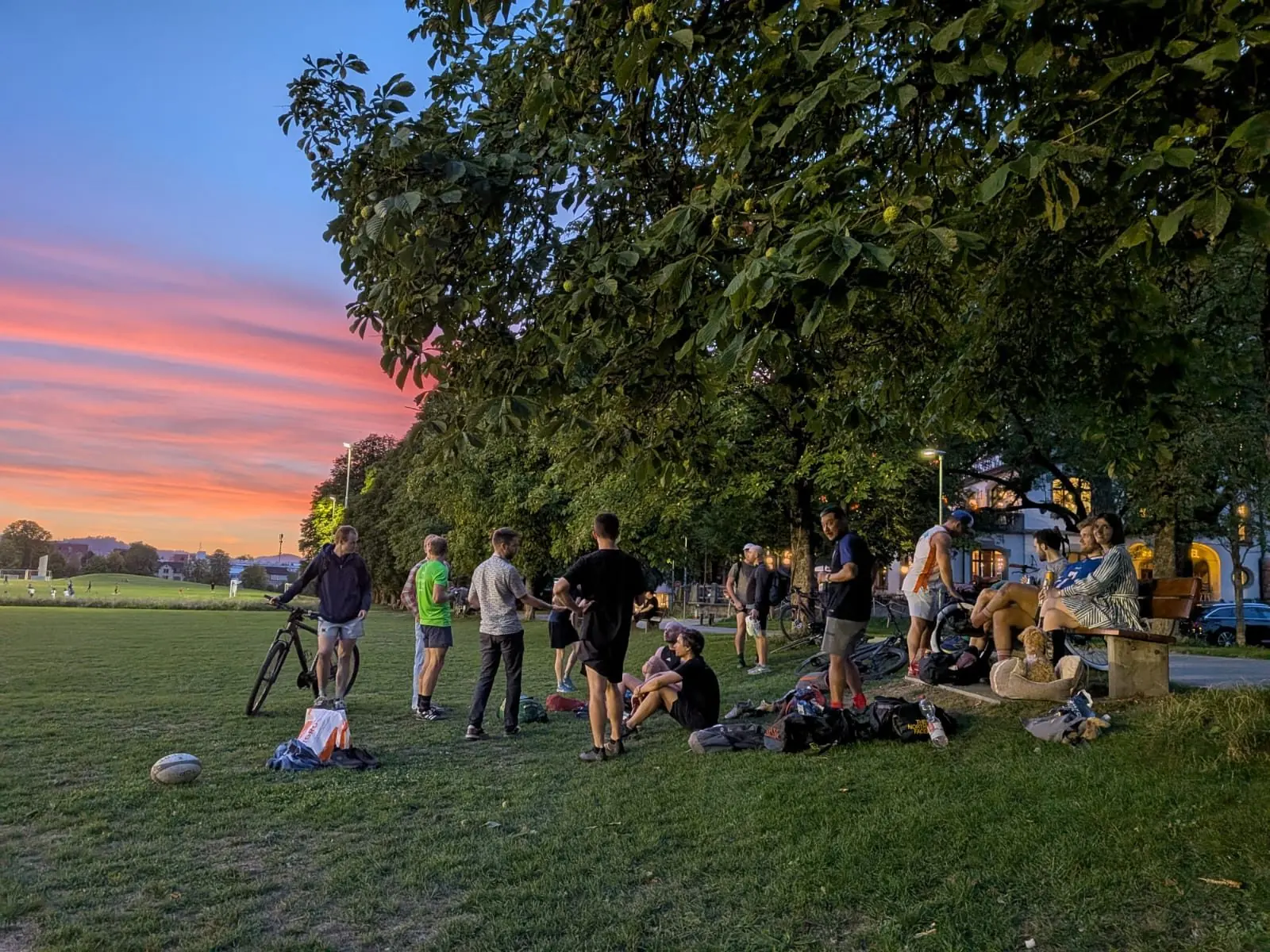 Players sharing drinks on the grass as the sun goes down