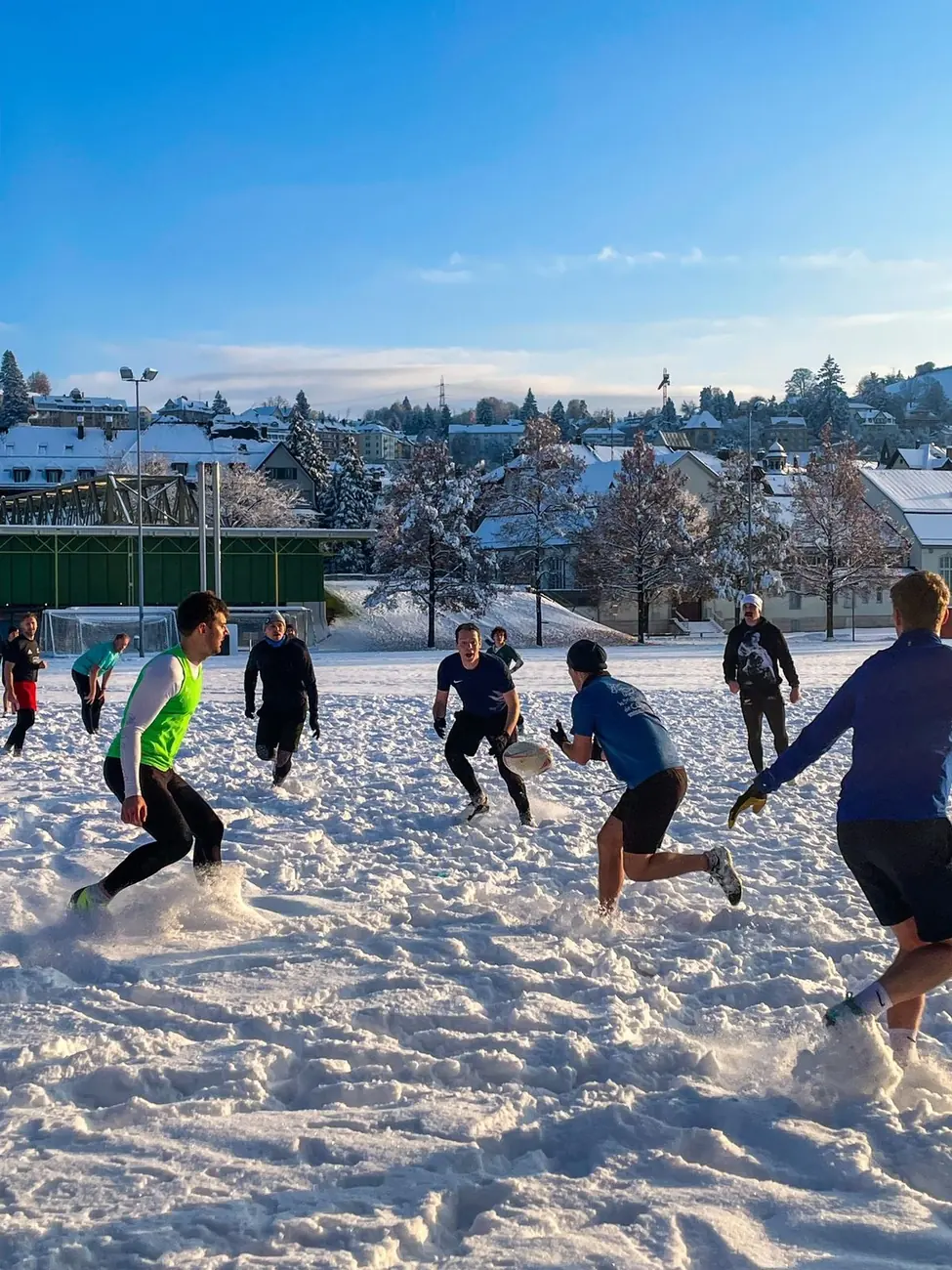 Players running through the snow during a winter session at the Kreuzbleiche